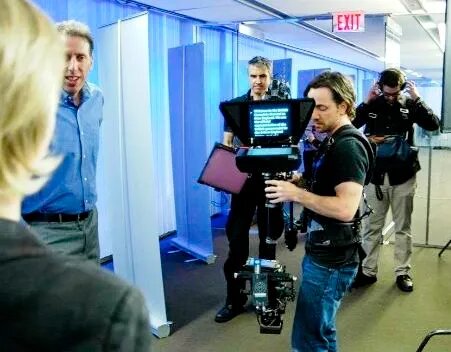 Crew member carrying a steadicam rig through the office